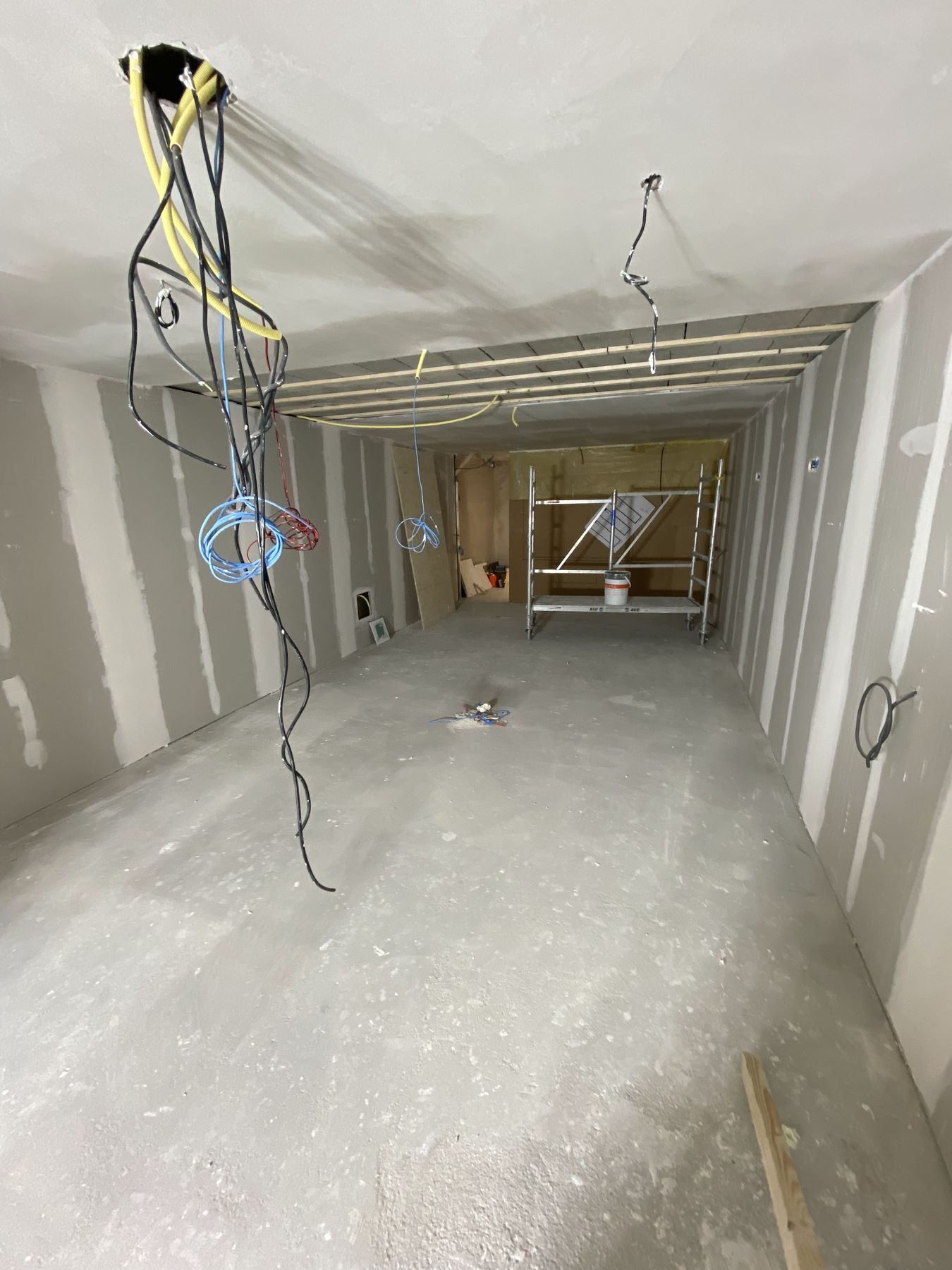 Ruimte in afbouw met gipsplaten wanden en plafond, bekabeling klaar